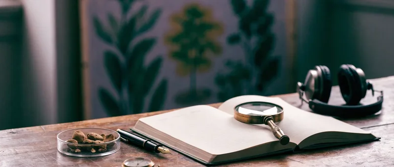 Research notebook, magnifying glass, headphones and dried mushrooms in a petri dish on a wooden table, evoking how scientists study psychedelic experiences